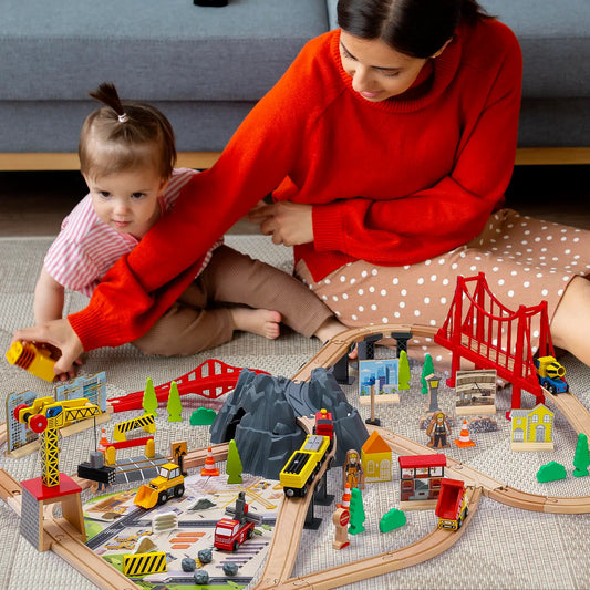 Woman and child playing with a wooden train set