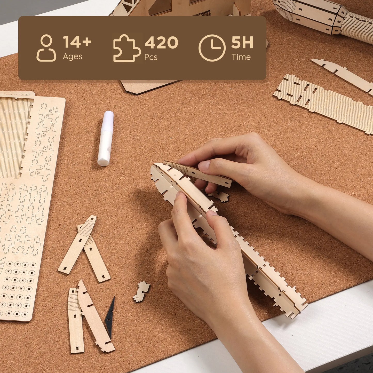 Person assembling wooden puzzle pieces on a corkboard