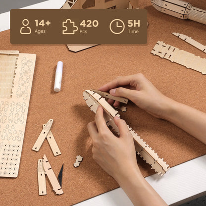 Person assembling wooden puzzle pieces on a corkboard