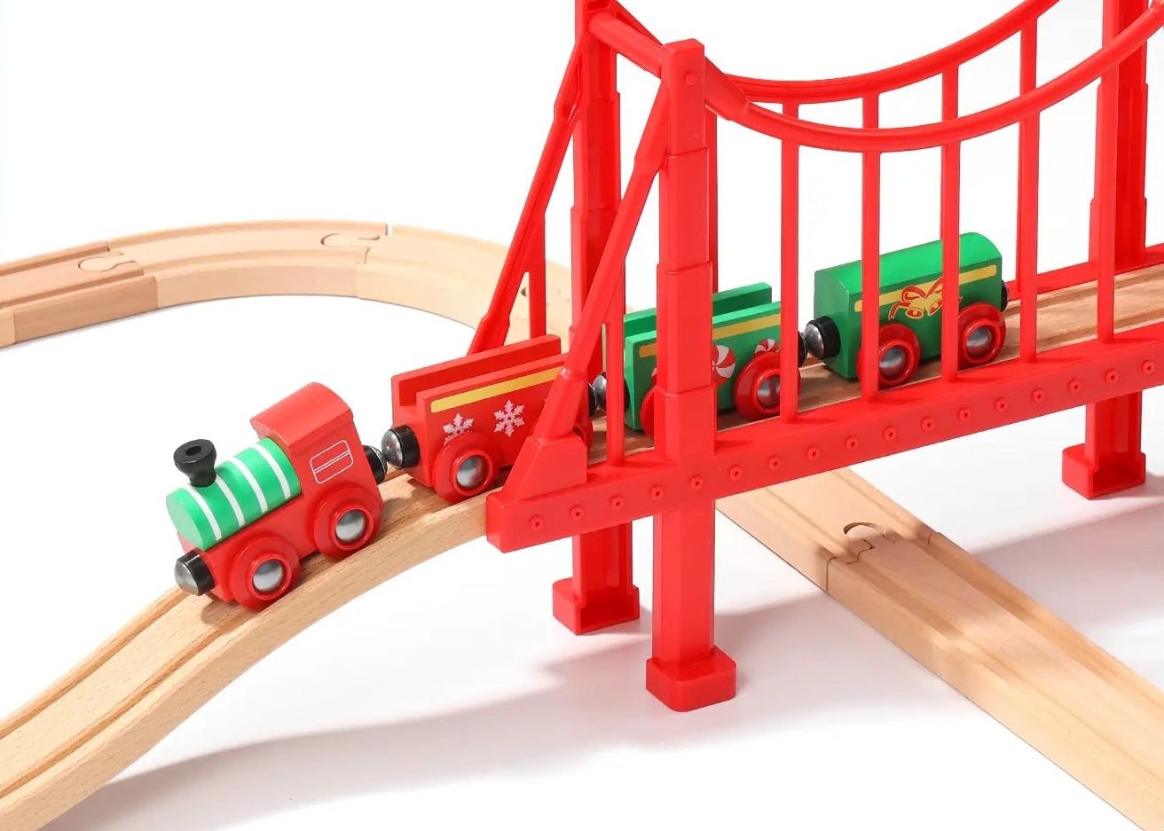 Wooden toy train set with red bridge, trees, and small buildings