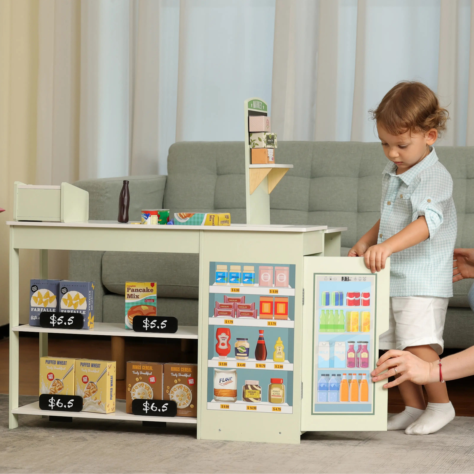 Woman and child playing with a toy kitchen set in a living room.
