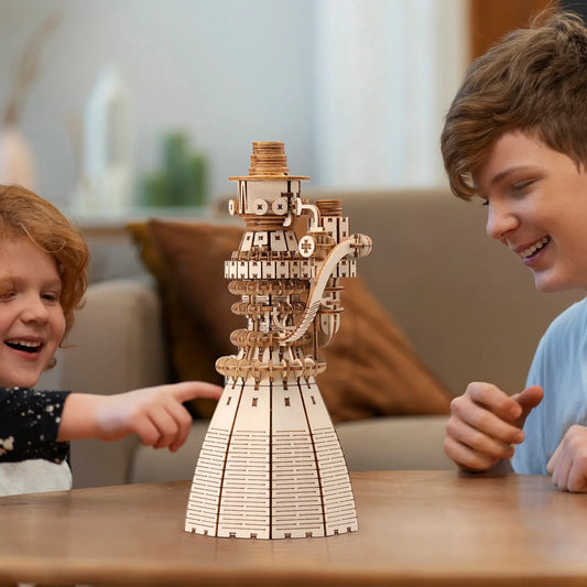 Two children playing with a wooden mechanical model on a table.