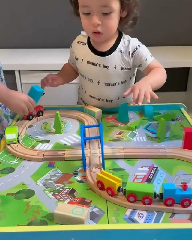 Child playing with a toy train set on a table