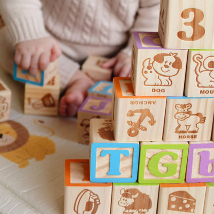 Child playing with wooden blocks featuring letters and animals