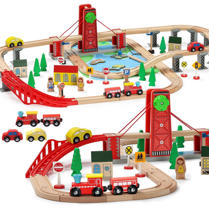 A wooden train track set with double-sided tracks, featuring red and blue trains, a bridge, tunnel, trees, and various track switches and decorations.
