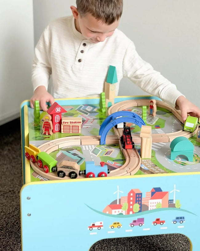 Child playing with a wooden train set on a table
