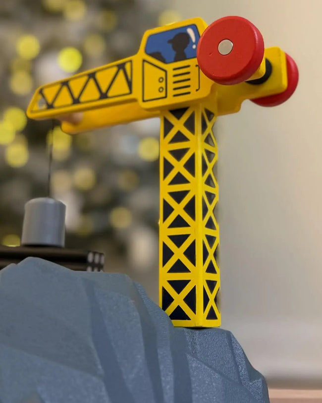 Toy crane figure on a gray surface with a blurred background