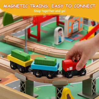 Toy train set with wooden tracks and colorful trains, featuring a hand interacting with the toys.