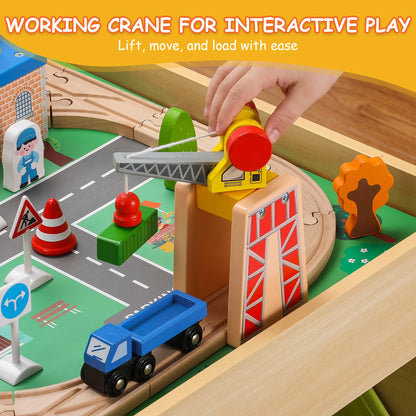 Wooden toy crane set with a hand lifting the crane over a toy truck on a wooden track.