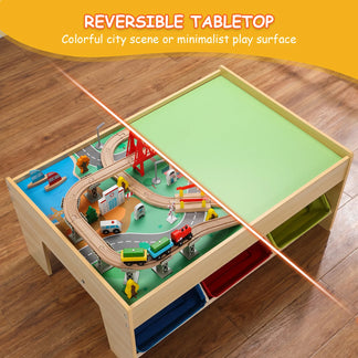 Children's play table with reversible top showing toy train set on colorful city scene and green minimalist surface.