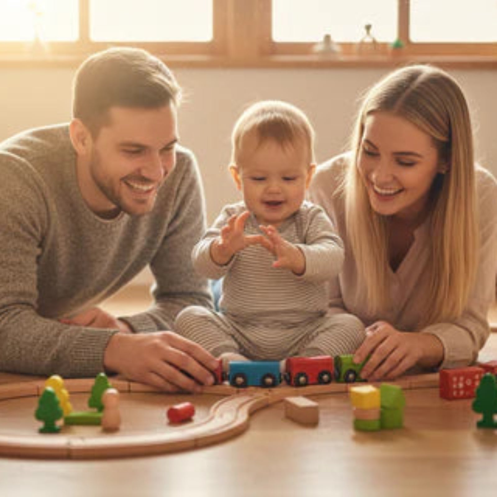 Family playing with wooden train toys 