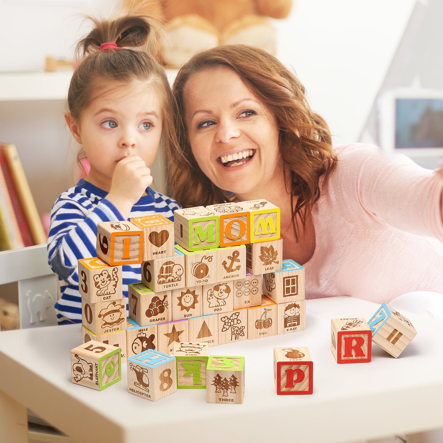Woman and child playing with wooden ABC blocks on a table