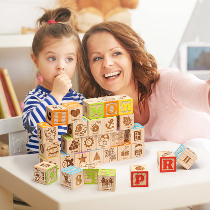 Woman and child playing with wooden ABC blocks on a table