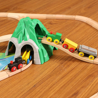 Wooden toy train set with tracks, tunnel, and small trains on a wooden surface